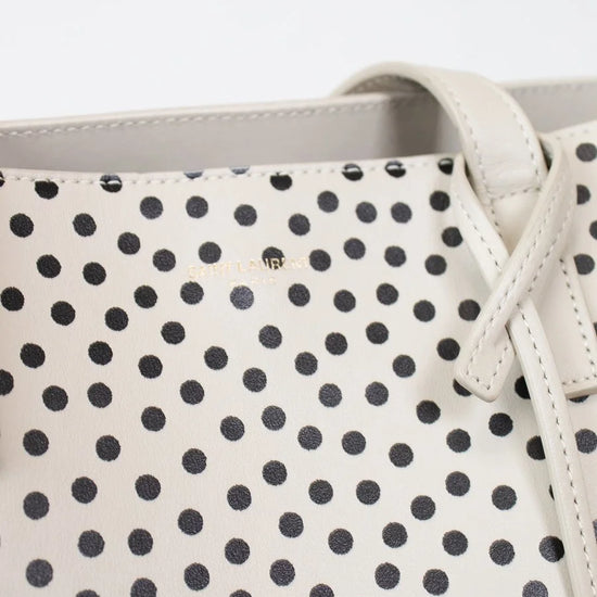 Close-up of a polka dot handbag with a visible brand logo.