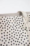 Close-up of a polka dot handbag with a visible brand logo.