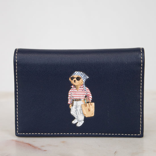 Navy blue wallet with bear design on a marble surface