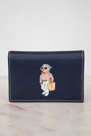 Navy blue wallet with bear design on a marble surface