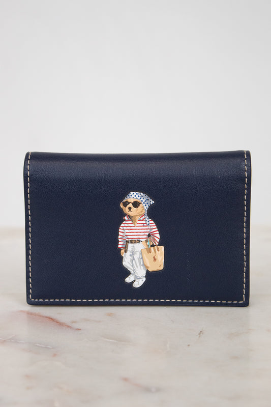 Navy blue wallet with bear design on a marble surface