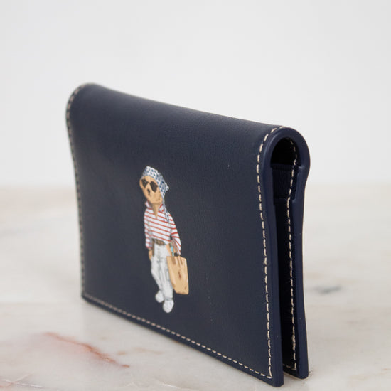Navy leather cardholder with bear design on a marble surface