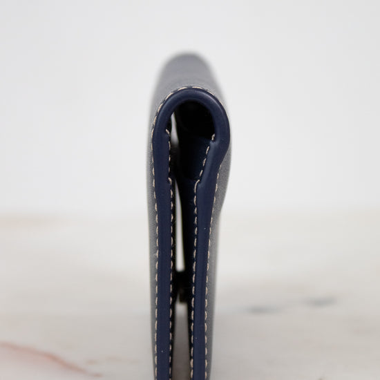 Navy blue leather wallet on a light marble surface