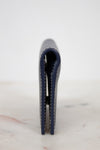 Navy blue leather wallet on a light marble surface