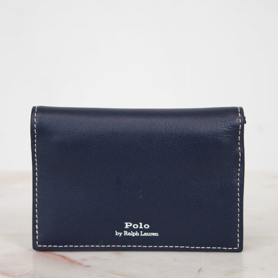 Navy leather wallet with 'Polo by Ralph Lauren' branding on a marble surface.