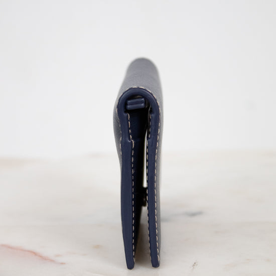 Navy blue wallet on a white marble surface