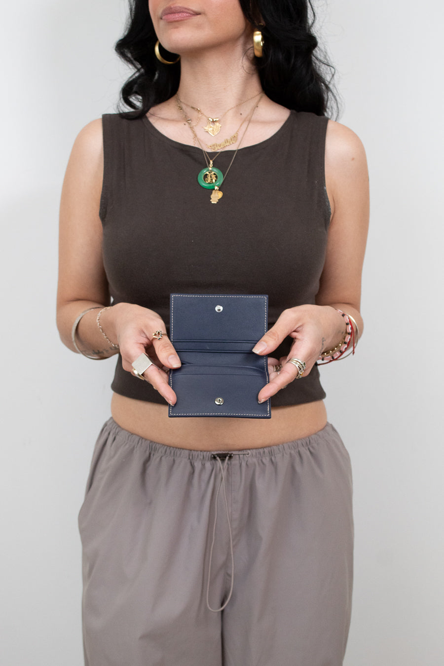 Woman holding a blue wallet against a plain background