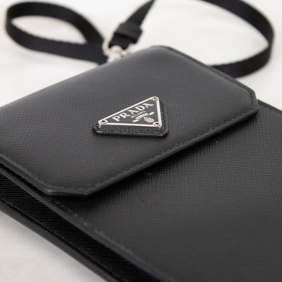 Black Prada handbag with a triangular logo on a white background