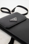 Black Prada handbag with a triangular logo on a white background