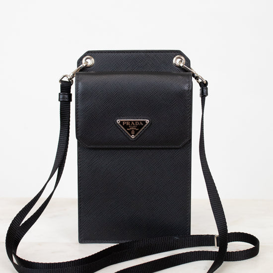Black crossbody bag with Prada logo on a white background