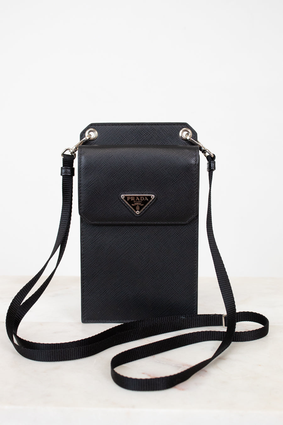 Black crossbody bag with Prada logo on a white background