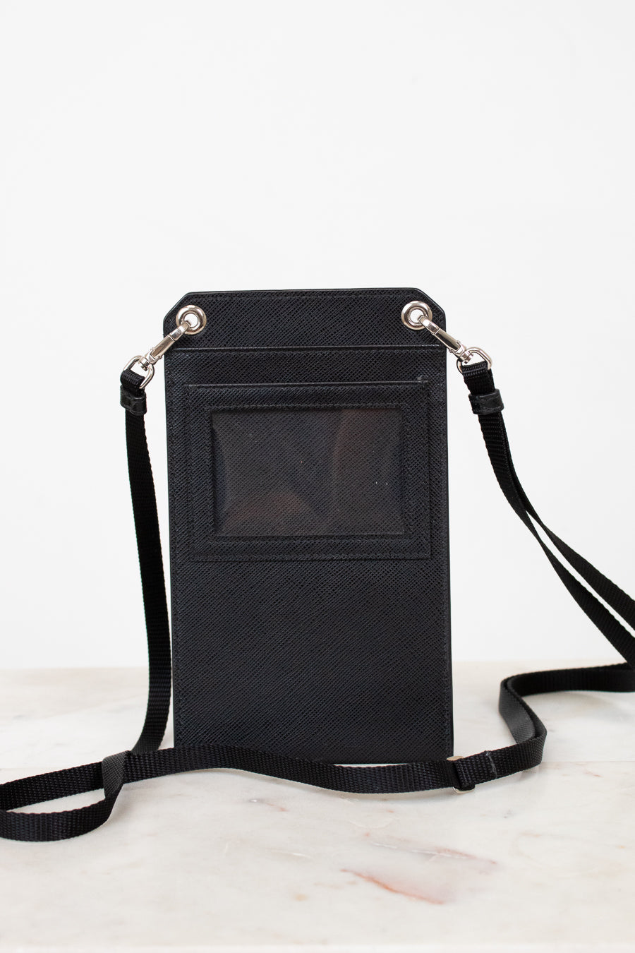 Black crossbody bag with a strap on a white background