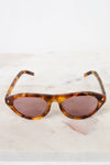 Sunglasses with tortoiseshell frame and brown lenses on a light background
