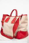 Beige and red handbag with gold accents on a white background