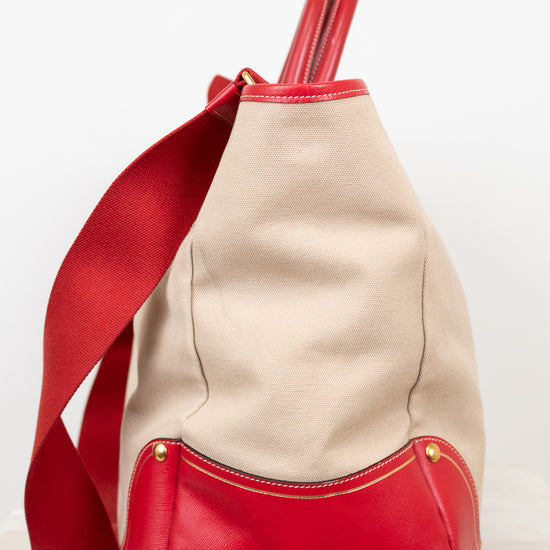 Beige and red handbag with a strap on a white background