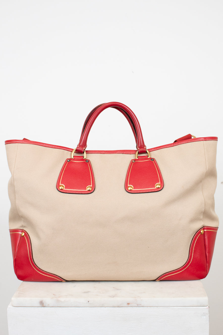 Beige tote bag with red accents on a white background