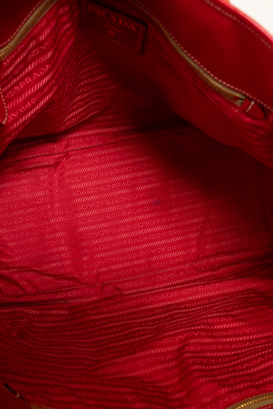 Close-up interior of a red textured fabric with a brand label.