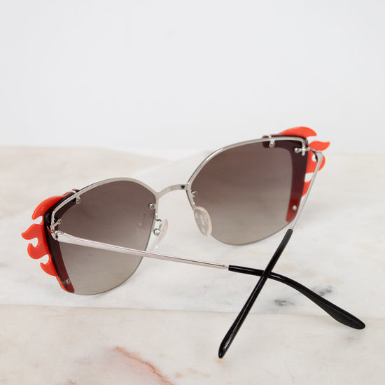Sunglasses with orange accents on a marble surface