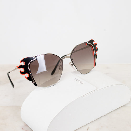 Sunglasses with decorative flame detail on a white surface
