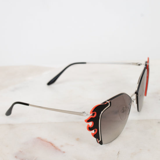 Sunglasses with flame-like design on a marble surface