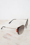 Sunglasses with flame-like design on a marble surface