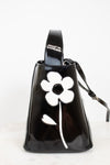 Black handbag with a white flower design on a white background