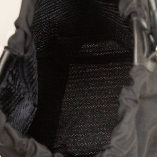 Interior of black nylon drawstring bucket bag showing printed lining and against a plain background