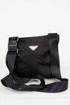 Black Prada bag with a strap on a white background