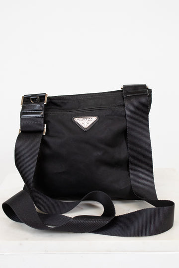 Black Prada bag with a strap on a white background