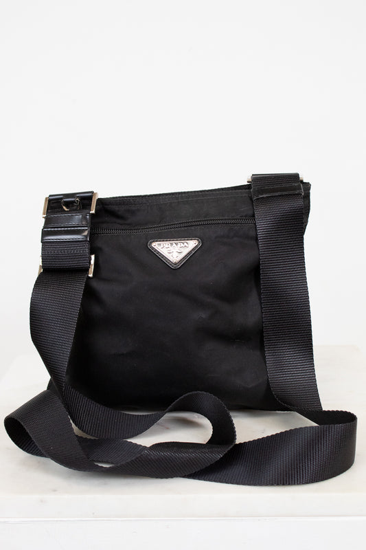 Black Prada bag with a strap on a white background