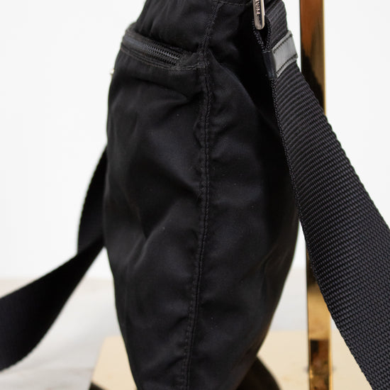 Black bag with a strap on a white surface