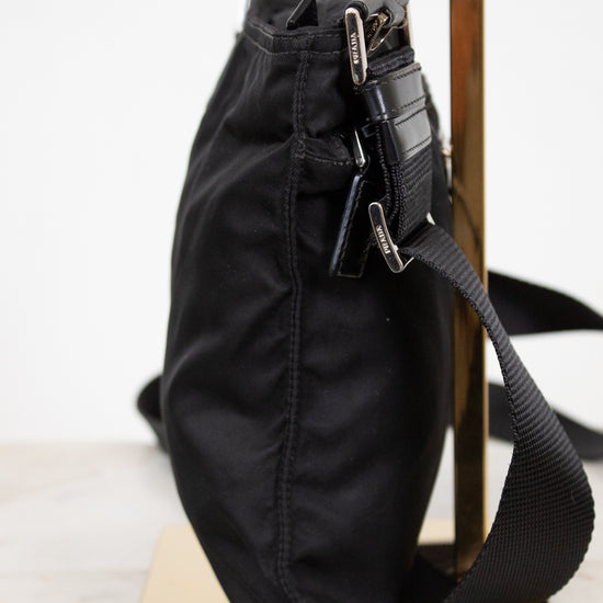Black bag with a strap on a white surface