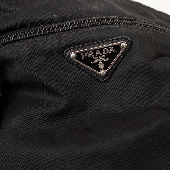 Close-up of a Prada logo on a black nylon fabric bag