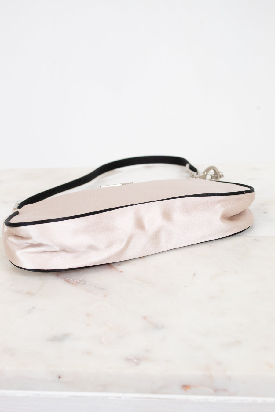 Pink satin handbag on a marble surface