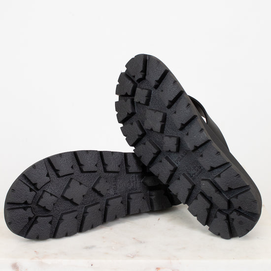 Black rubber sandals on a light gray background