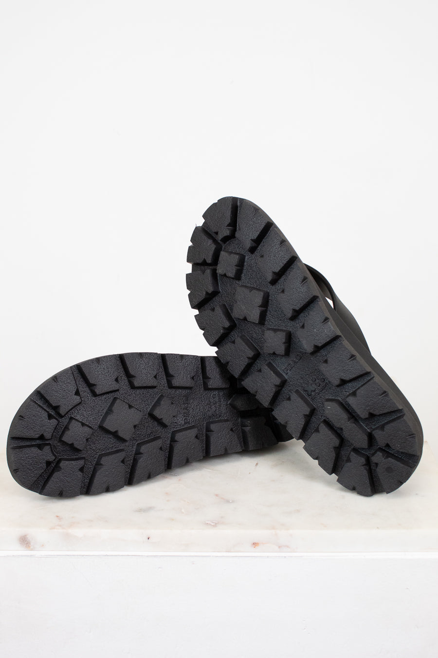 Black rubber sandals on a light gray background