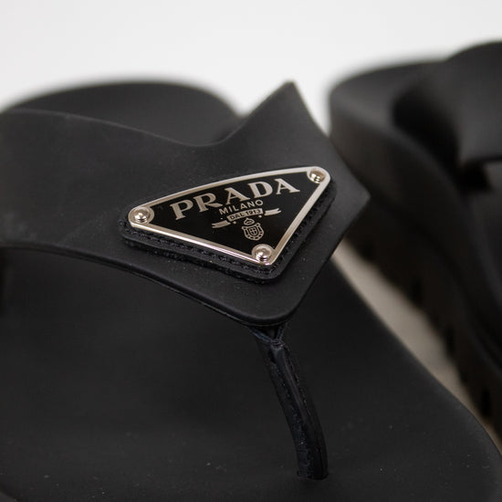 Black sandal with Prada logo on a white background