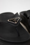 Black sandal with Prada logo on a white background