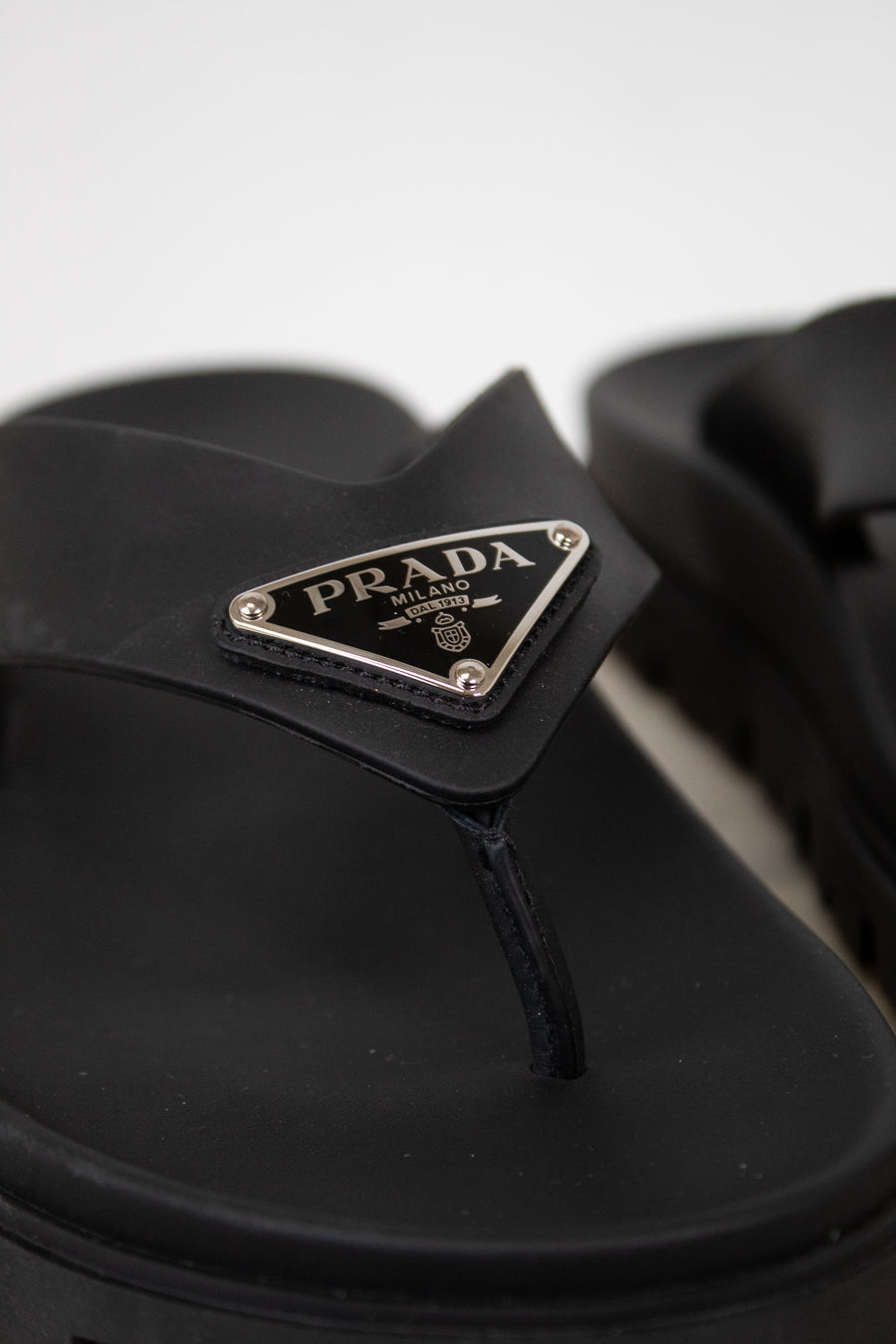 Black sandal with Prada logo on a white background