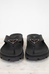 Black Prada sandals on a light background