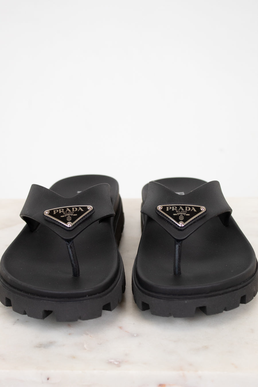 Black Prada sandals on a light background
