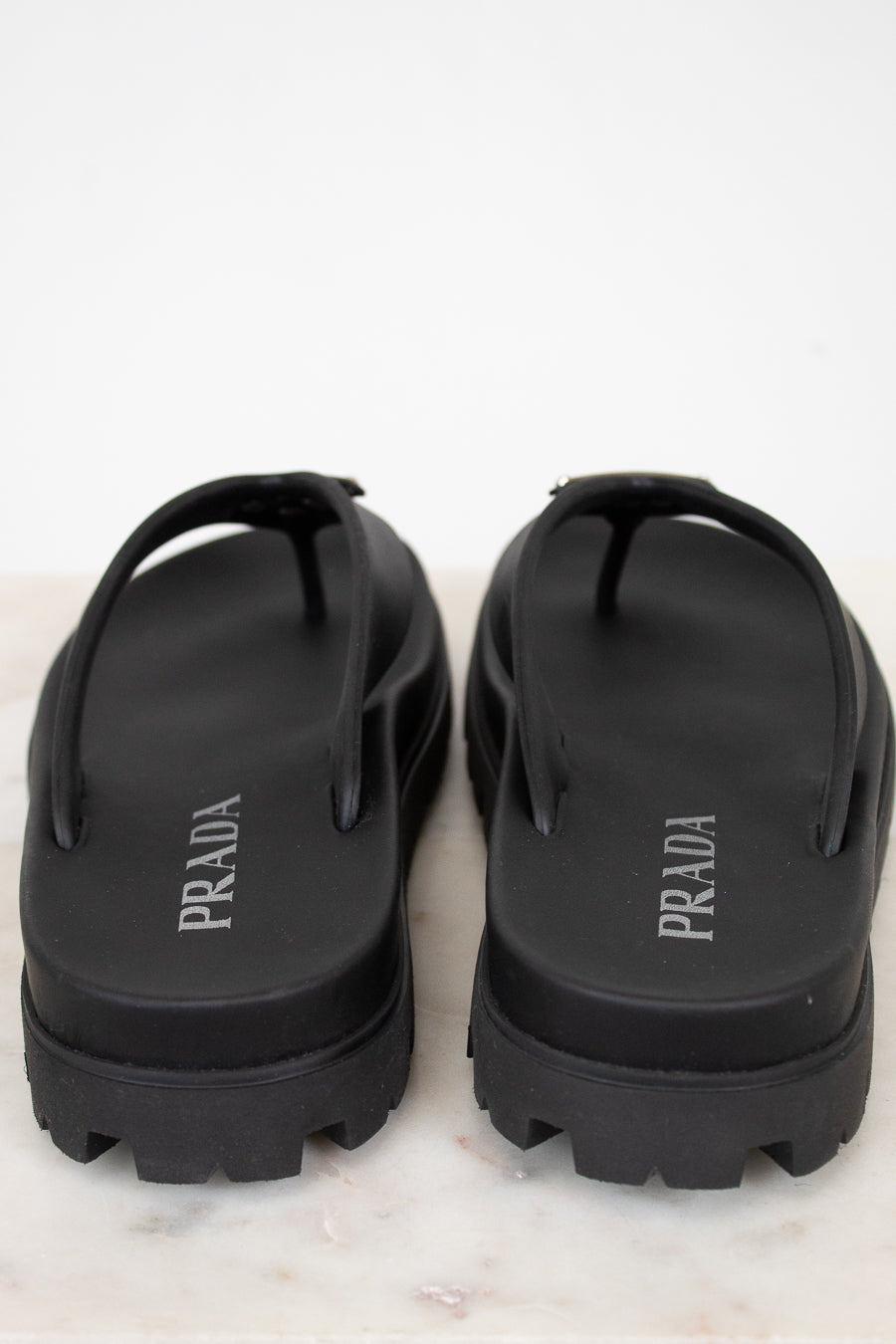 Black Prada sandals on a white background