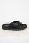 Black sandal with Prada logo on a light marble background