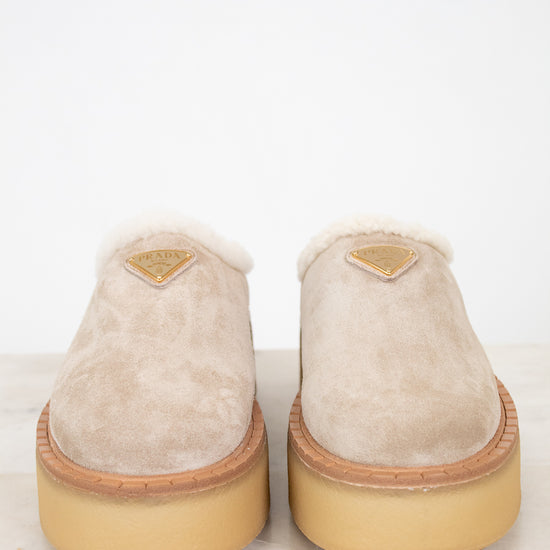 Pair of beige slippers with gum soles on a white background