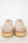 Pair of beige slippers with gum soles on a white background