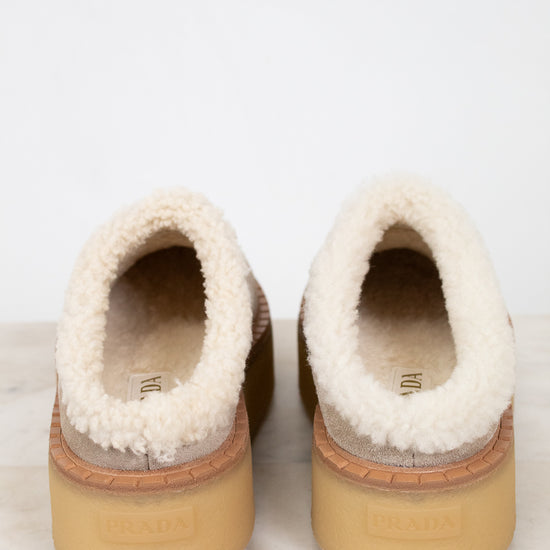 Pair of slippers with fluffy white shearling interior on a light background