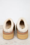 Pair of slippers with fluffy white shearling interior on a light background