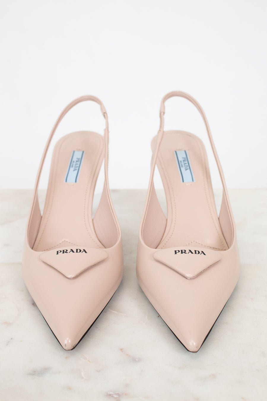 Pair of nude Prada high heels on a light background