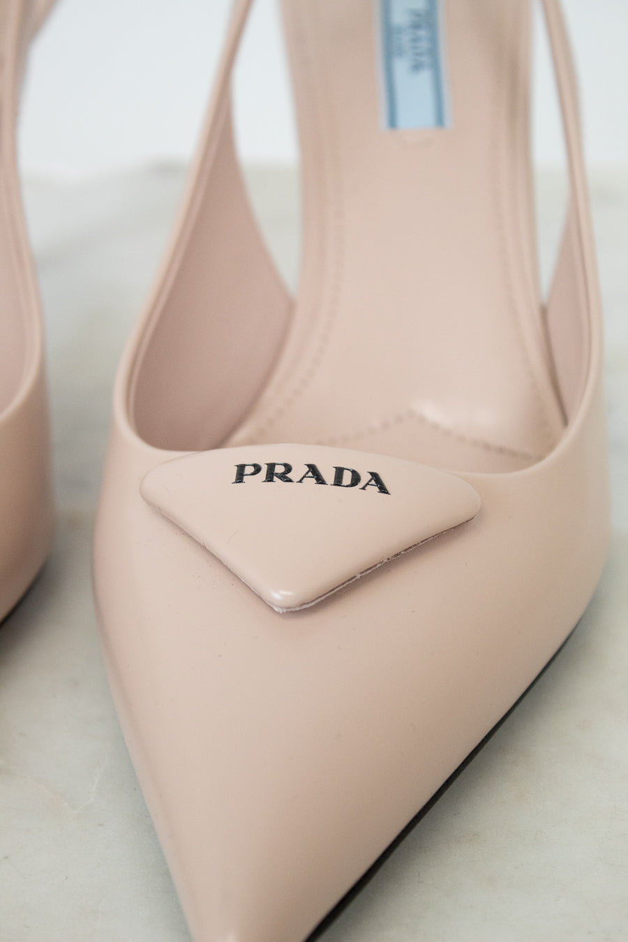 nude/pink Prada heeled shoes on a light background