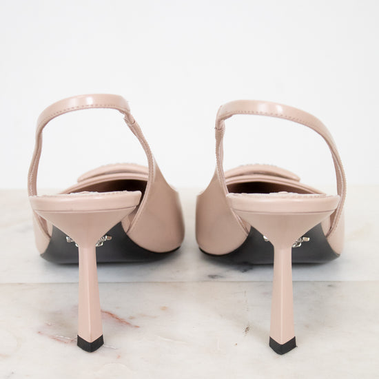 Pair of beige high-heeled shoes on a light marble surface